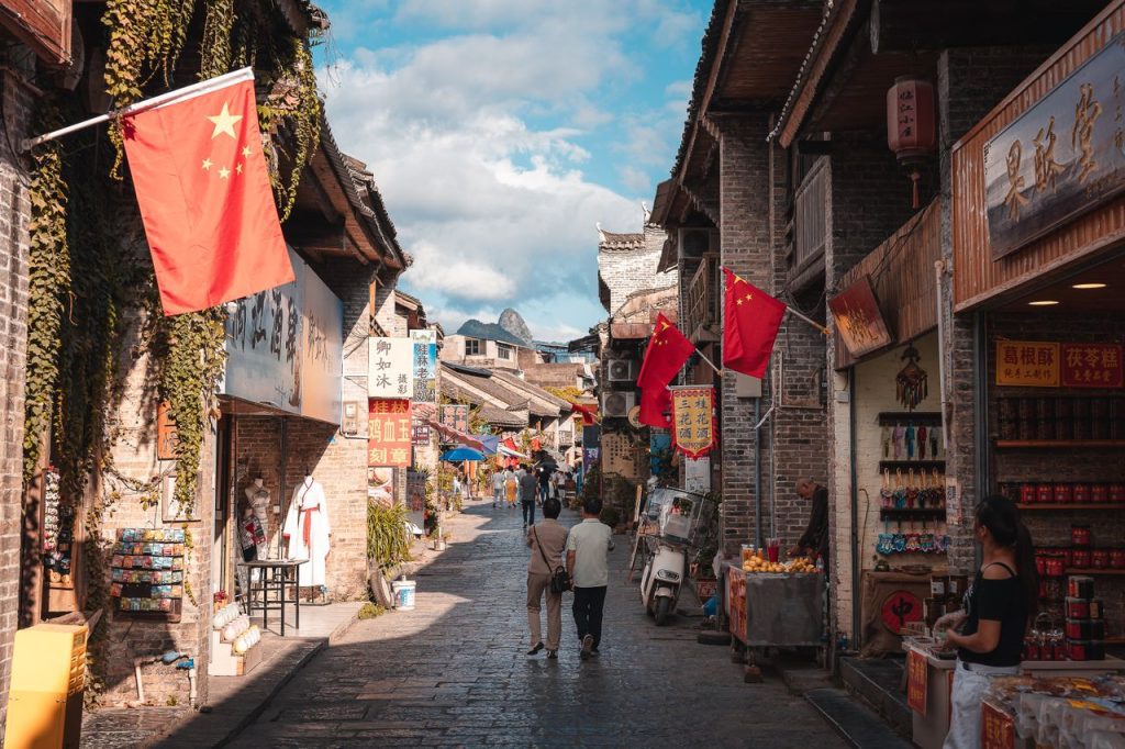 A vibrant street market scene in Xingping, China, showcasing traditional architecture and local shops.